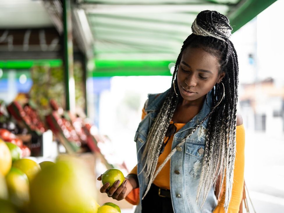 girl holding fruit at market